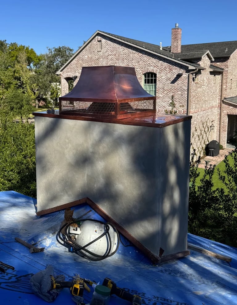 Large metal chimney installation on residential roof with brick house and construction materials visible